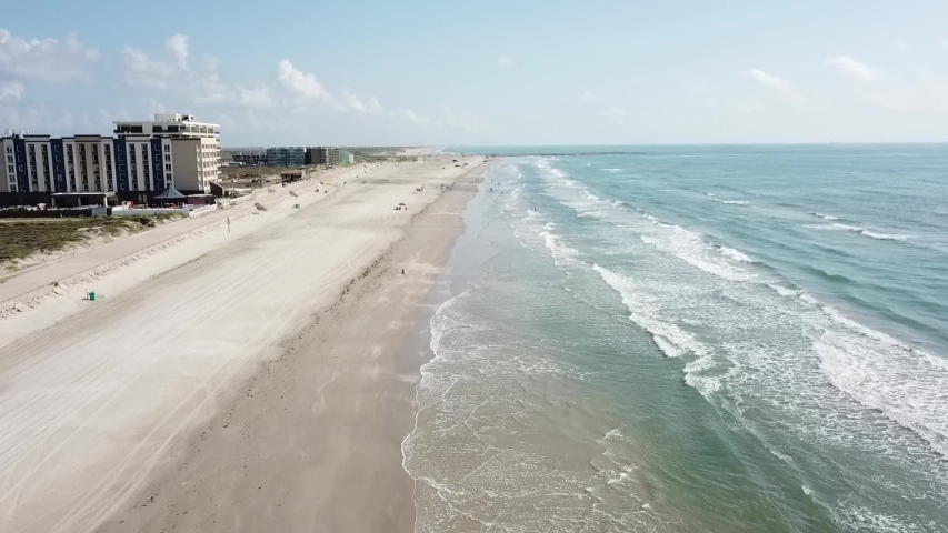 Aerial view moving up the beach and over the surf above Padre Island, Corpus Christi Texas Royalty-Free Stock Footage #1054286801
