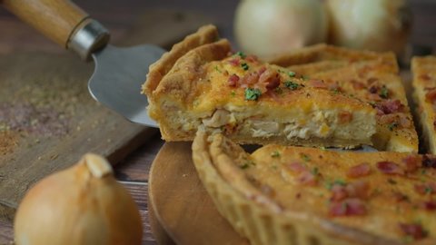 Chef serving Quiche lorraine or French tart, an savoury open pie with cheese.