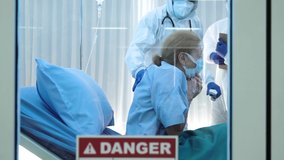 slow motion of senior caucasian coronavirus covid-19 infected patient with medical mask lying on bed coughing heavily from pneumonia in quarantine room at hospital with doctor and medical team  - Powered by Shutterstock - Get 15% off with code: PIKWIZARD15