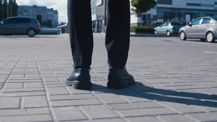 Rear back view feet of businessman commuting to work. Confident guy in leather shoes and suit being on his way to office building | Shutterstock HD Video #1054293320