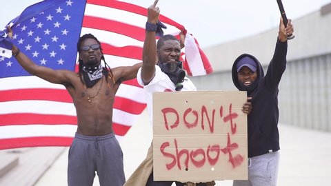Group of young protesting American male holding piece of cardboard with text - don't shoot.