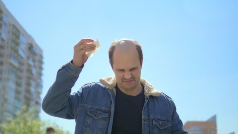 A bald man is walking along the streets of the city. a dove shit on the head of a bald man. humor.