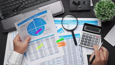 Top view of businessman working with financial statements. Modern black office desk with notebook, calc, pen and a lot of things. Flat lay table layout.


