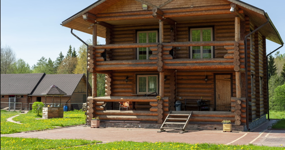 Time-lapse father and son collect scaffolding near his home. A two-story log house in a picturesque setting, controversial work on the assembly of the structure, the movement of households and pets.