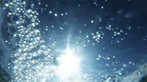 Underwater Bubbles with sunlight through water surface, natural slow motion under water scene
