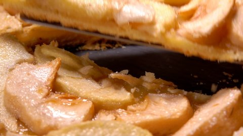 Delicious homemade apple pie taken out from black board with spatula