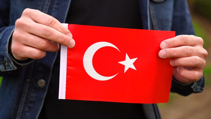 Man holding Turkish flag outdoors. Independence Day, or national holidays concepts.