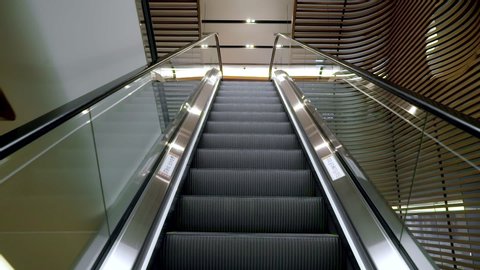 Moving up the escalator with glass sides and metal steps