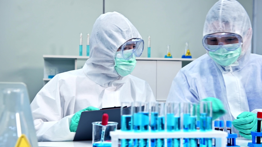 Scientist team has researching and working on Coronavirus cure in the laboratory. Asian Doctor examining samples and applying a vaccine against virus infection. | Shutterstock HD Video #1054306979