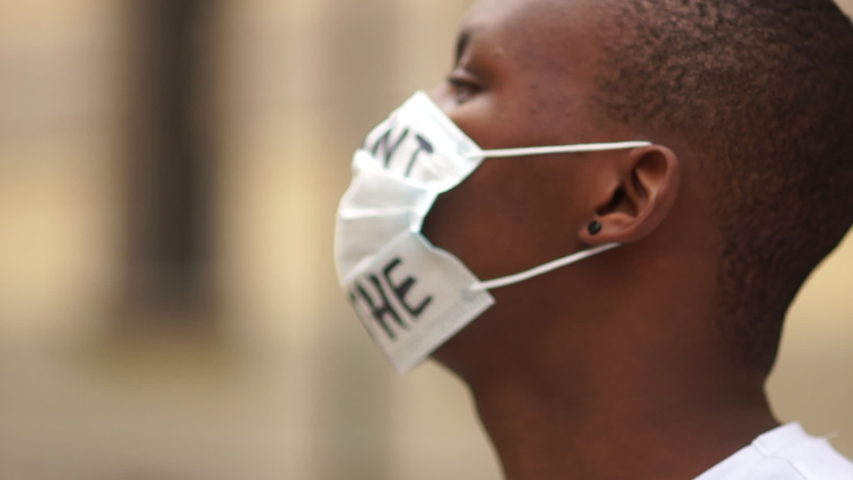 Black lives matter, mass protests against racism in the USA and Europe. Outdoor portrait of a African American in a medical mask with the inscription I cant breathe Royalty-Free Stock Footage #1054310912