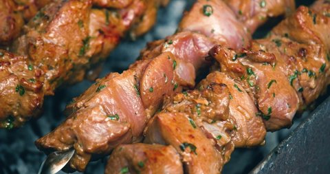 Rotating the skewers. Shish kebab. Pork or lamb meat pieces being fried on a charcoal grill. Frying grilled pieces of meat during the rest. Close up, 4k	
