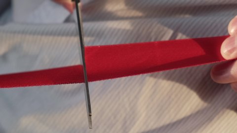Cutting red ribbon as a symbol of opening a new enterprise, closeup