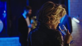 Closeup beautiful blonde lady with short hair drinking some champagne at the party then came close to her friends - Powered by Shutterstock - Get 15% off with code: PIKWIZARD15