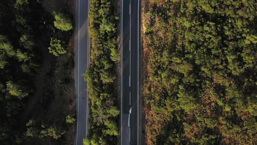 Aerial drone top view over natural reservoir in Algarve, Portugal. Sunset Landscape. Car passing by on a small road.