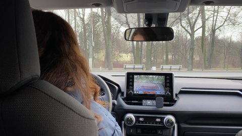SAINT PETERSBURG, RUSSIA - CIRCA APRIL 2020: Female driver driving her car, woman parks Toyota RAV4 in parking lot using rear view camera