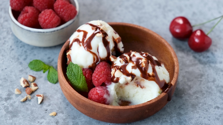 Eating homemade ice cream sundae. Vegetarian vanilla ice cream with fruits and chocolate syrup | Shutterstock HD Video #1054328789