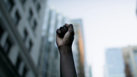 Raised black man's fist in protest. Social justice and peaceful protesting racial injustice. 