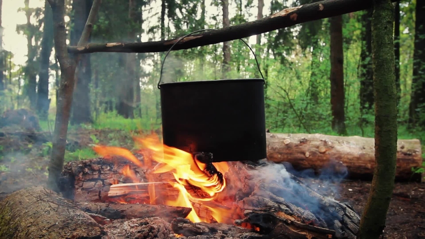 Preparing of cooking in woods outdoor. Cook soup or porridge with meat in hiking trip. Tourist warms up dinner in campfire. Camp on travel, place for bonfire. Survival in wild adventure in summer Royalty-Free Stock Footage #1054341287