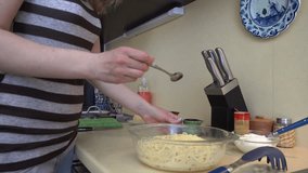 Female hands put red sauce on spaghetti pasta in dish. Preparing vegetarian food. Static closeup shot. 4K UHD video clip.