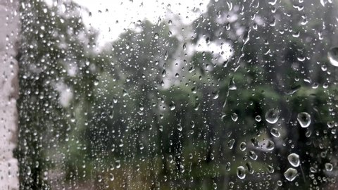 Raindrops through the glass. Storm, hurricane and strong wind through the glass