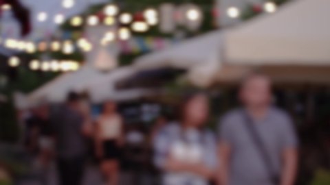 4k out of focus video footage of many calm blurry people of different ages walking in streets of evening sunset city.