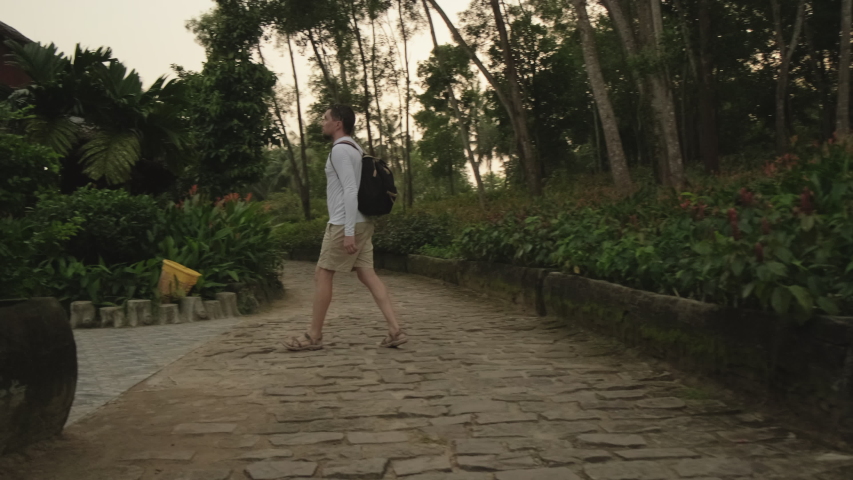 Man traveler exploring the area of ecological park. Landscape design and paved paths