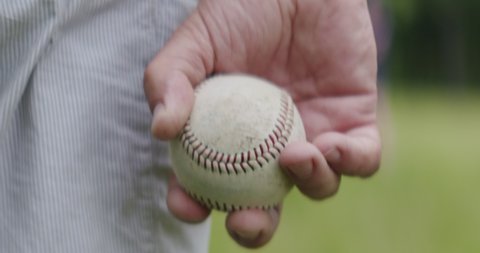 Adult man holding a baseball ball in his hands while playing catch with his son.