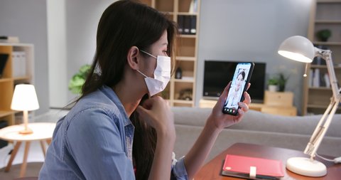 Telemedicine concept - Asian female doctor explain about disease to the patient by smartphone video chat with ok gesture