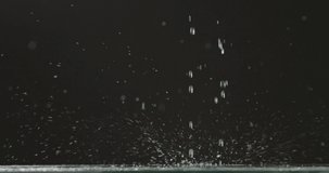 Droplets of water and ripe cherries fall from a height on a flat surface. Water droplets and splashes scatter in different directions on a black background. Slow motion. Full HD video, 240fps,1080p