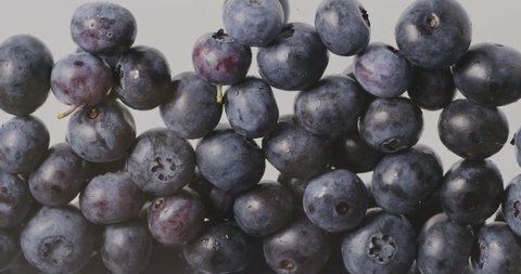 Filling the screen with a large ripe blueberries. Close-up of falling berries. Blueberry background. Slow motion. Full HD video, 240 fps, 1080p