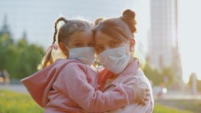 Masked mother holds lovely child in hands on street walk during coronavirus epidemic. Mom hugs daughter, wearing medical face masks at quarantine, tired of pandemic, close up. - Powered by Shutterstock - Get 15% off with code: PIKWIZARD15