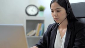 Close up asian business woman receptionist wear headphone and feel tired after video conference customer support service. Slow Motion Full HD.