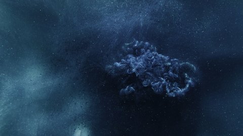 Ink water explosion. Magic spell. Blue glitter smoke motion on dark abstract background.