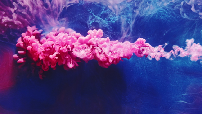 Color ink splash. Mysterious illusion. Pink smoke cloud puff on blue steam abstract background.