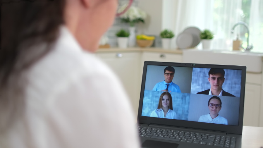 Online working distance learning video call chat conference remote work call webcam meeting concept. Back view woman chatting colleagues team business partner coach laptop home. Coronavirus COVID-19.  Royalty-Free Stock Footage #1054359635