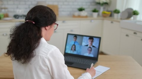 Online distance learning video conference webinar call remote work  webcam meeting concept. Back view woman talk colleagues team business partner coach at laptop home. Coronavirus COVID-19. 4 K