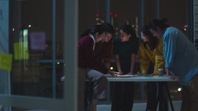 Group of Asia young creative people in smart casual wear discussing business brainstorming meeting ideas mobile application software design project in modern night office. Coworker teamwork concept. - Powered by Shutterstock - Get 15% off with code: PIKWIZARD15