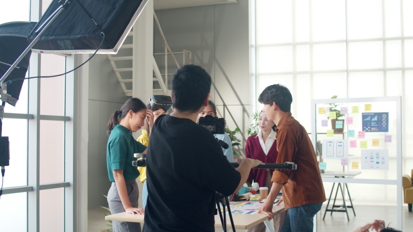 Behind the scenes of video production crew team shooting group of Asia young creative people discussing business brainstorming meeting ideas mobile application software design project in office. Royalty-Free Stock Footage #1054362809
