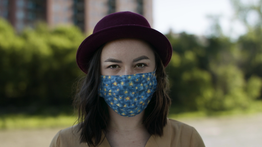 Portrait of a young modern woman wearing a stylish face mask. Medical mask protection for pandemic virus. Shot in 4k.  Royalty-Free Stock Footage #1054365062