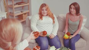 Two girl. Bulimic and overweight girl trying fresh fruits and vegetables. Doctor talking about weight problem and consults about health issues. Healthy food concept. Tinted video. Prores 422. 