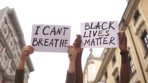 Protests against racism and discrimination in the US and Europe. Young african man and caucasian woman holding a cardboard posters with the message text I CANT BREATHE and BLACK LIVES MATTER