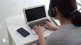 Asian woman using headphone and computer to work from home. video call conference and technology concept