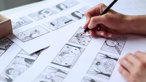 Hands of the artist designer draw a storyboard on paper. Storytelling. Story frames with heroes.