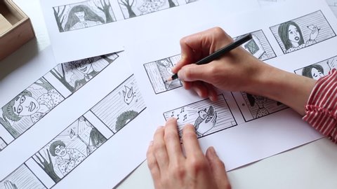 Hands of the artist designer draw a storyboard on paper. Storytelling. Story frames with heroes.
