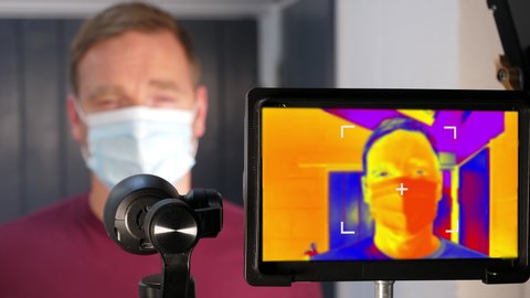 4K: Thermal Imaging Scanning Camera on a man with face mask to have his Temperature Checked. Heat scan for virus . Stock Video Clip Footage