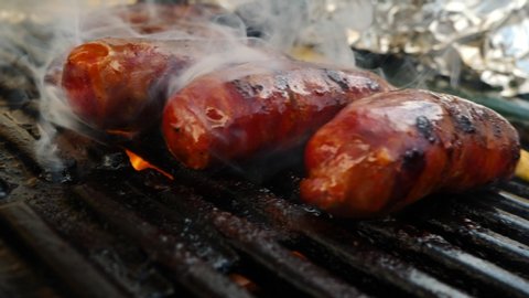 close-up view of tasty sausages grilling on charcoal grill
