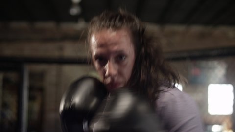 Female MMA fighter throws punches directly into camera