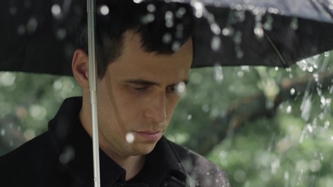 Man under umbrella at the funeral