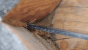 Close-up of a carpentry chisel caulking a log cabin. Clogs tow in the gap between the logs. High quality UHD video.