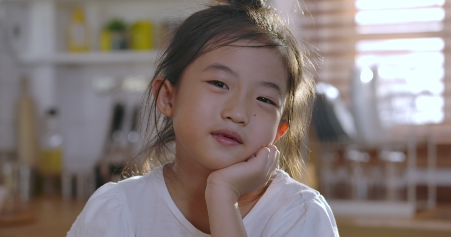 Close up portrait of Young asian little girl smiling with a toothless smile. Show no teeth.